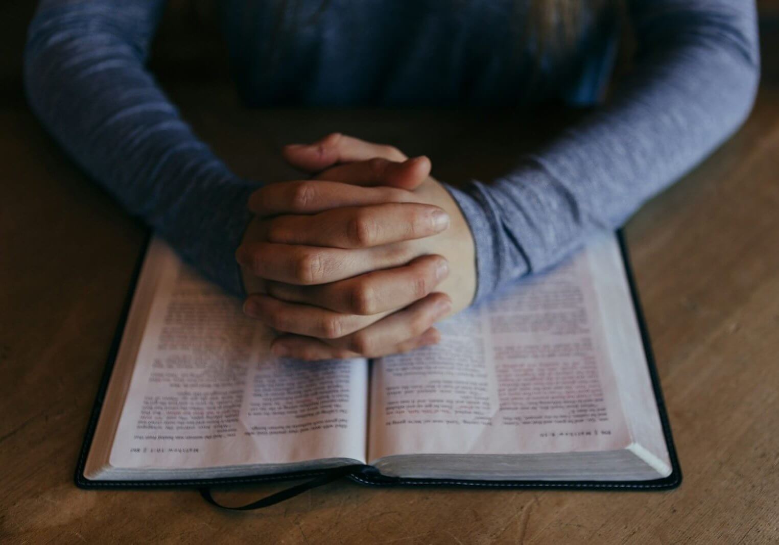 man holding his hands on open book